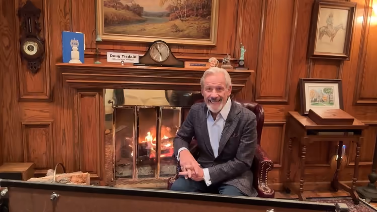 Doug seated beside the fireplace for his first Fireside Chat