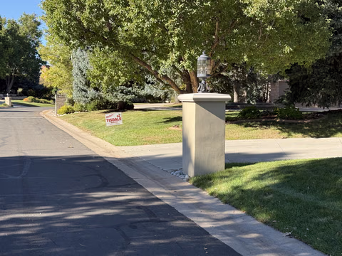 A Doug Tisdale sign on a lawn beside a residential drive.